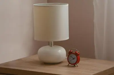 a lamp and an alarm clock on a table at Love Apartment in Vrnjačka Banja