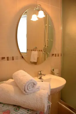 a bathroom with a sink and a mirror and towels at Love Apartment in Vrnjačka Banja