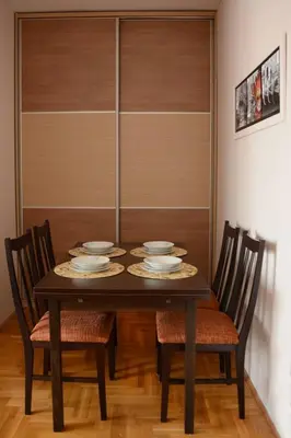 a dining room table with chairs and plates on it at Love Apartment in Vrnjačka Banja