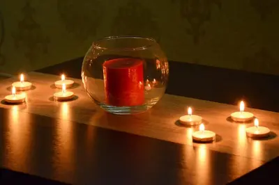 a glass vase with candles on a wooden table at Love Apartment in Vrnjačka Banja
