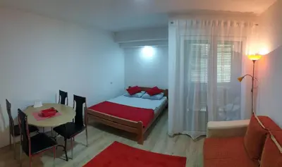 a bedroom with a bed and a table and a room with a tableablish at Apartman 4 - Studio Janja in Soko Banja