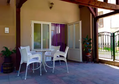 a patio with white chairs and a table on a porch at Filip Apartments in Soko Banja
