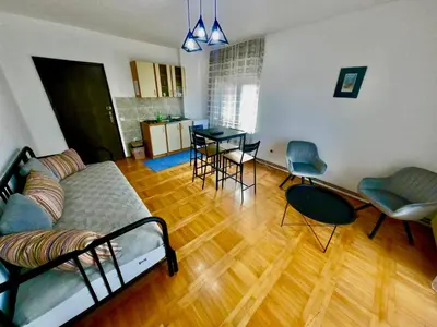 a living room with a bed and a table and chairs at Filip Apartments in Soko Banja
