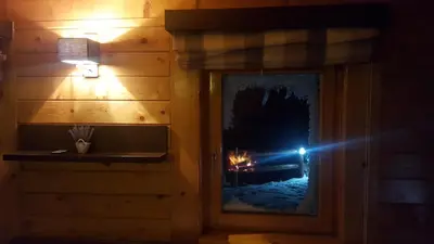 a person taking a picture of a fire in a window at Holiday Home Floris in Kopaonik