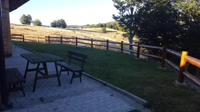 a picnic table and two chairs and a fence at Holiday Home Floris in Kopaonik