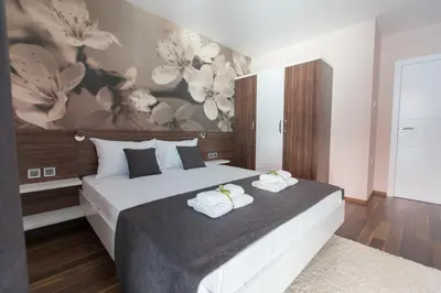 a bedroom with a large bed with towels on it at Garni Hotel Niš City View & Spa in Niš