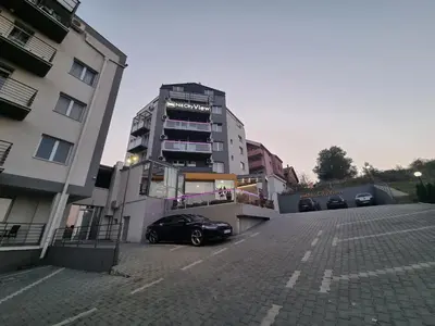 a car parked in a parking lot next to a building at Garni Hotel Niš City View & Spa in Niš
