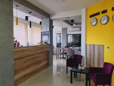 a restaurant with a waiting room with clocks on the wall at Garni Hotel Niš City View & Spa in Niš