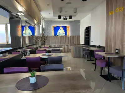 a restaurant with wooden tables and purple chairs at Garni Hotel Niš City View & Spa in Niš