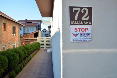 a sign on the side of a building that reads stop at Lotos Depandans in Niš