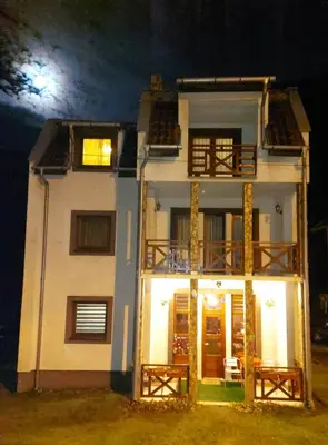 a large white house with the moon in the background at Marko'S Apartments in Kopaonik