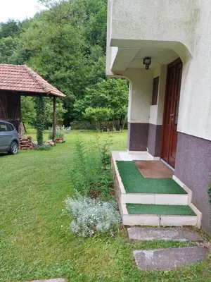 a house with a porch with a grass yard at Marko'S Apartments in Kopaonik