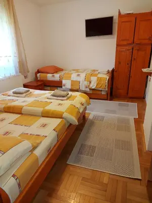 a room with three beds and a tv on a wall at Marko'S Apartments in Kopaonik