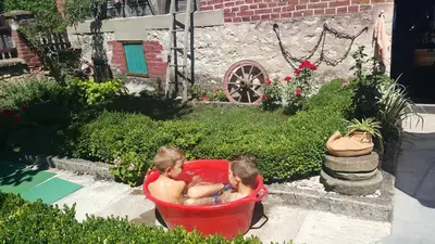 two boys sitting in a red bath tub at Vila Milenovic Rajacke Pivnice in Rajac