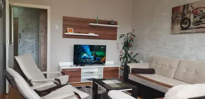 a living room with a couch and a tv at Apartman Sweet dreams 1 in Niš