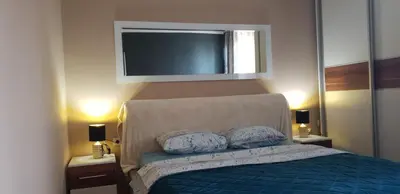 a bedroom with a blue bed with two pillows at Apartman Sweet dreams 1 in Niš
