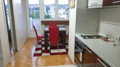 a kitchen with a table and two red chairs at Apartman Sweet dreams 1 in Niš