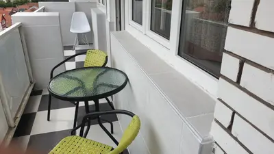a small balcony with a table and two chairs at Apartman Sweet dreams 1 in Niš