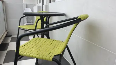 a yellow chair sitting next to a small table at Apartman Sweet dreams 1 in Niš