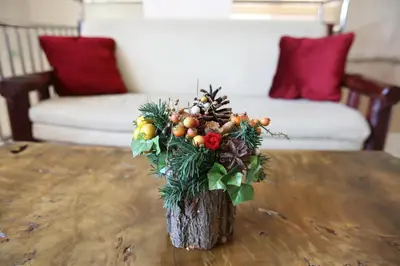a vase with a christmas arrangement on a table at Cuki Residence in Mala Ravna Reka