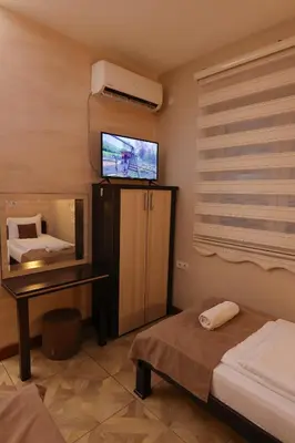 a bedroom with a tv and a bed and a table at Cuki Residence in Mala Ravna Reka