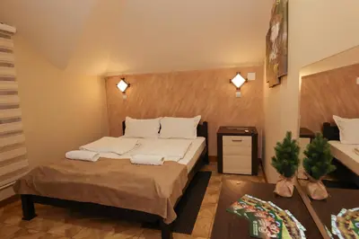 a small bedroom with a bed and a table at Cuki Residence in Mala Ravna Reka
