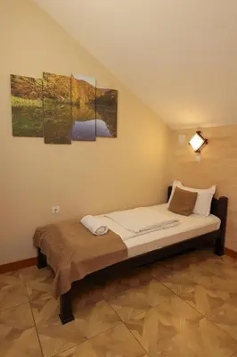 a bed in a room with three paintings on the wall at Cuki Residence in Mala Ravna Reka