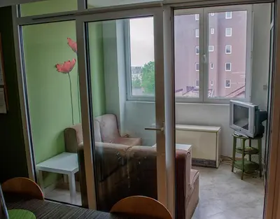 a living room with a chair and a television at Sweet Apartments or Rooms in Niš