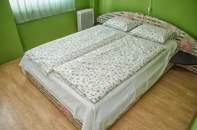a bed in a room with a green wall at Sweet Apartments or Rooms in Niš