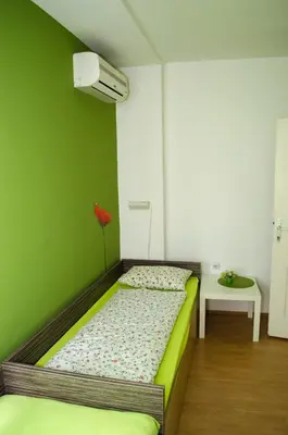 a bed in a room with a green wall at Sweet Apartments or Rooms in Niš