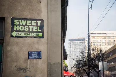 a sign on the side of a building that reads sweet hostel at Sweet Apartments or Rooms in Niš