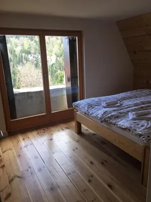 a bedroom with a bed and a sliding glass door at Holiday Home Elena in Kopaonik