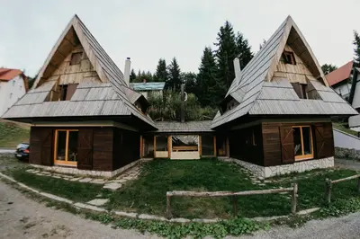 a house with a gambrel roof with a yard at Holiday Home Elena in Kopaonik