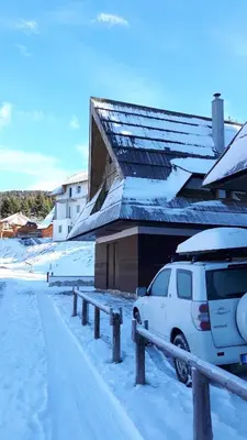 a white van parked next to a building in the snow at Holiday Home Elena in Kopaonik