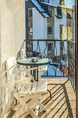 a balcony with a table and chairs on a balcony at Vila Čajetinski biser-Apartment Classic in Kopaonik
