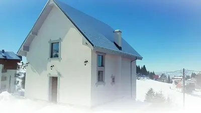 a small white house in the snow at Vila Čajetinski biser-Apartment Classic in Kopaonik