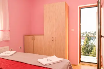 a bedroom with a bed and a cabinet and a window at Vila Čajetinski biser-Apartment Classic in Kopaonik