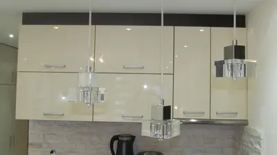 a kitchen with white cabinets and chandeliers at Apartments Vanja i Vrh in Kopaonik