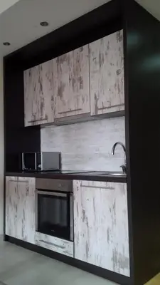 a kitchen with wooden cabinets and a sink at Apartments Vanja i Vrh in Kopaonik