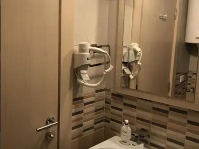 a bathroom with a sink and a mirror and a toilet at Apartments Vanja i Vrh in Kopaonik
