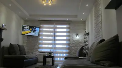 a living room with two couches and a flat screen tv at Apartments Vanja i Vrh in Kopaonik