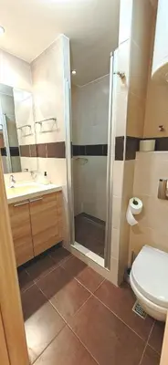 a bathroom with a shower and a toilet and a sink at Apartments KOP Konaci in Kopaonik