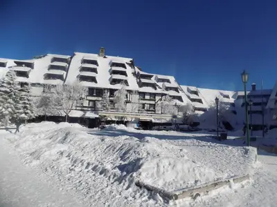 a snow covered building with a pile of snow at Apartment Sofia-Konaci in Kopaonik
