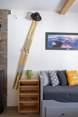 a room with a bed and a set of skis on the wall at Alpine Retreat Čupino Sokače in Kopaonik