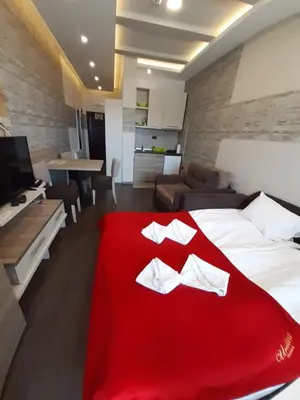 a bedroom with a red blanket on a bed at Panorama apartments in Milmari Resort in Kopaonik