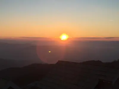 a sunset over the mountains with the sun in the sky at Panorama apartments in Milmari Resort in Kopaonik