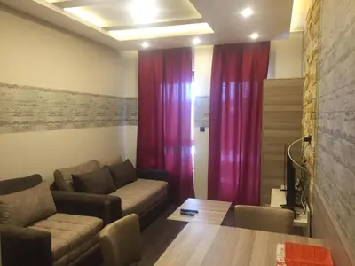 a living room with a couch and red curtains at Panorama apartments in Milmari Resort in Kopaonik
