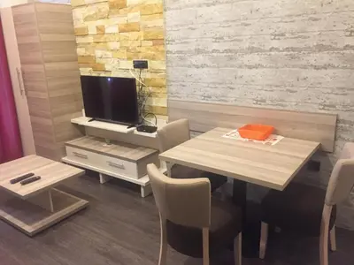 a dining room with a table and a tv at Panorama apartments in Milmari Resort in Kopaonik
