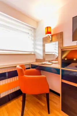 an orange chair in a room with a desk at Apartments Mozaik in Kopaonik