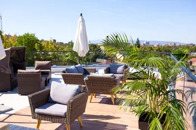 a patio with chairs and tables on a roof at Apel Luxury in Niš